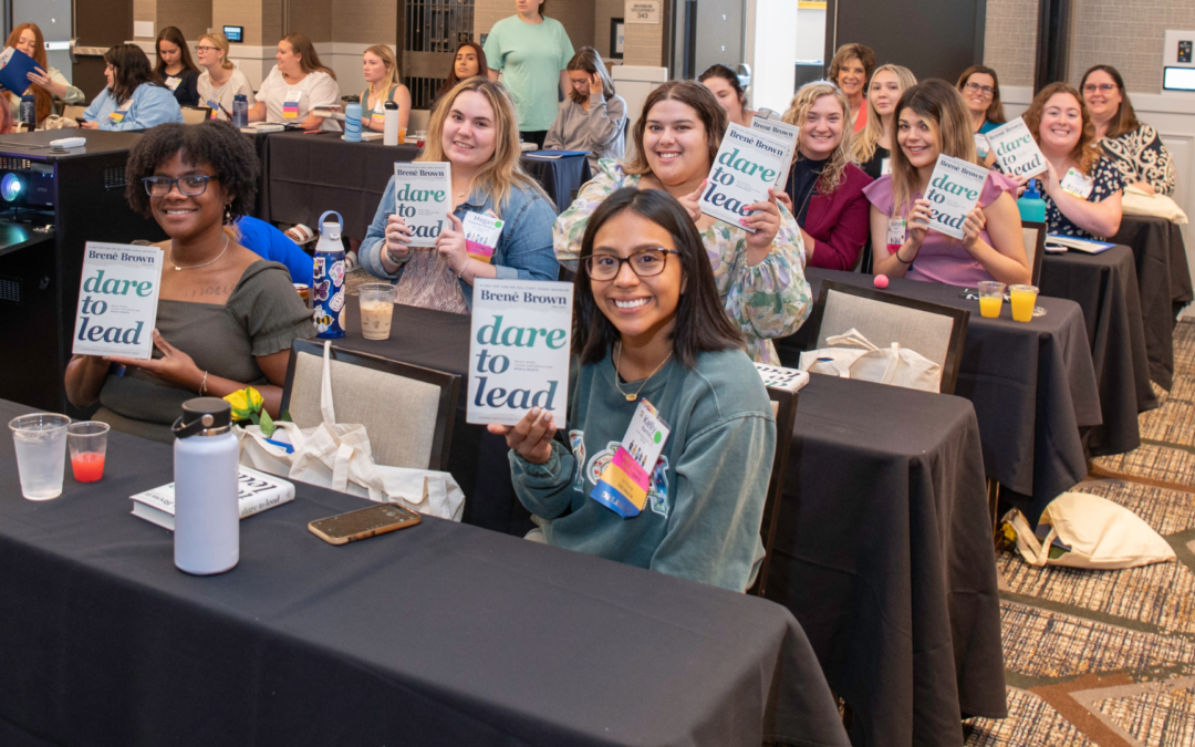 Members at Convention with Leadership books provided by Omega Phi Alpha Foundation